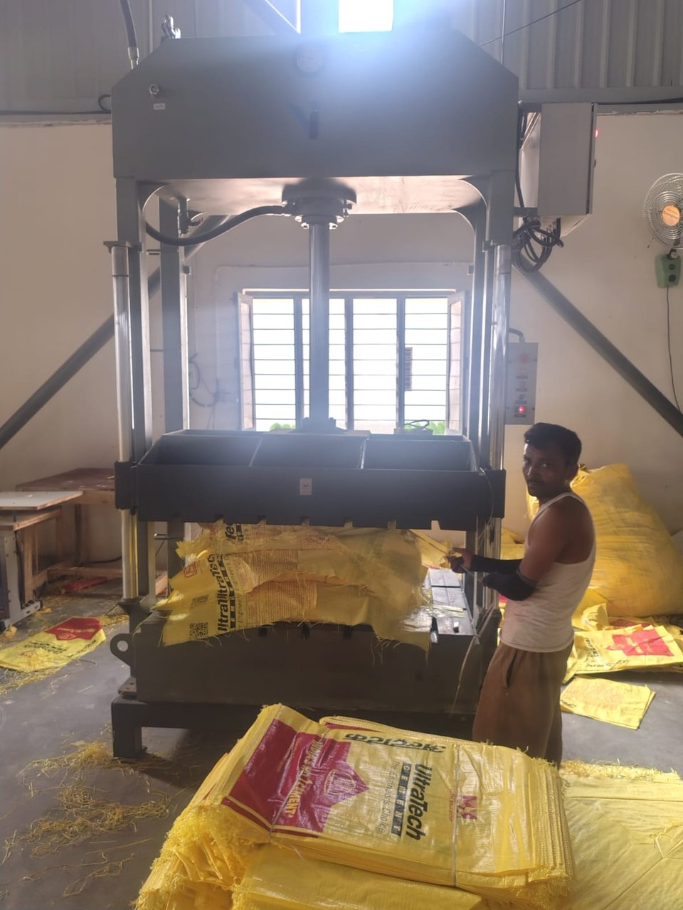 Hydraulic bale press compressing UltraTech cement bags