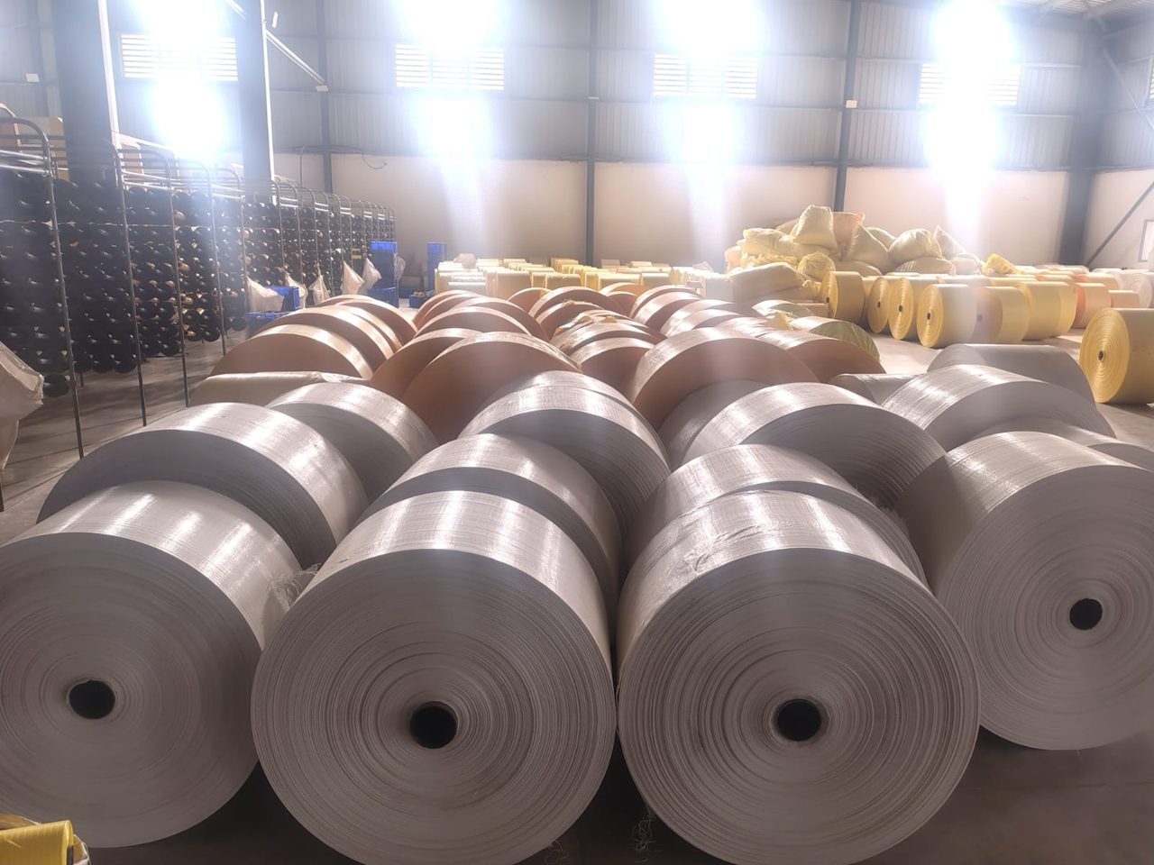 Creel of white yarn bobbins feeding a loom