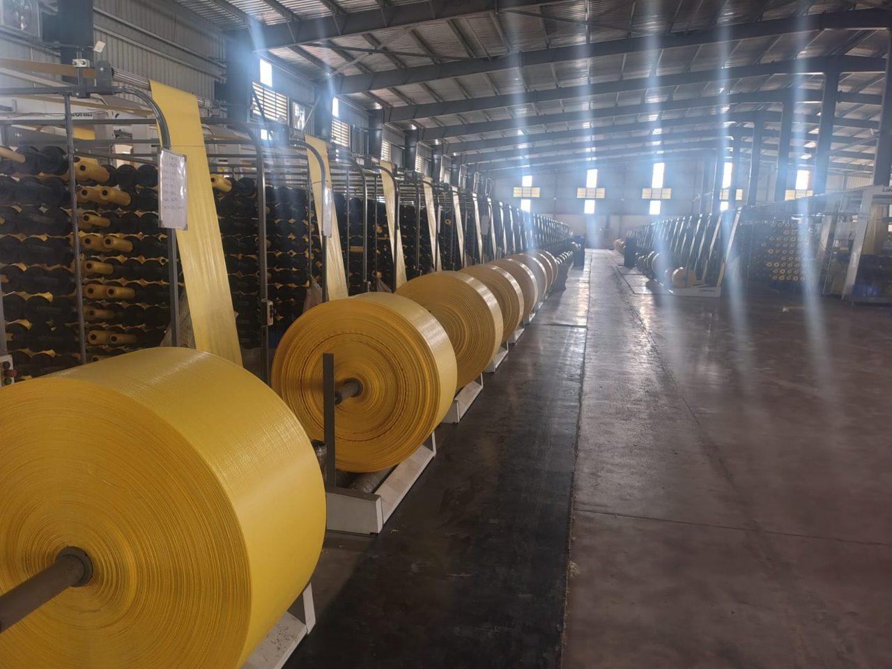 Row of woven fabric rolls in plant